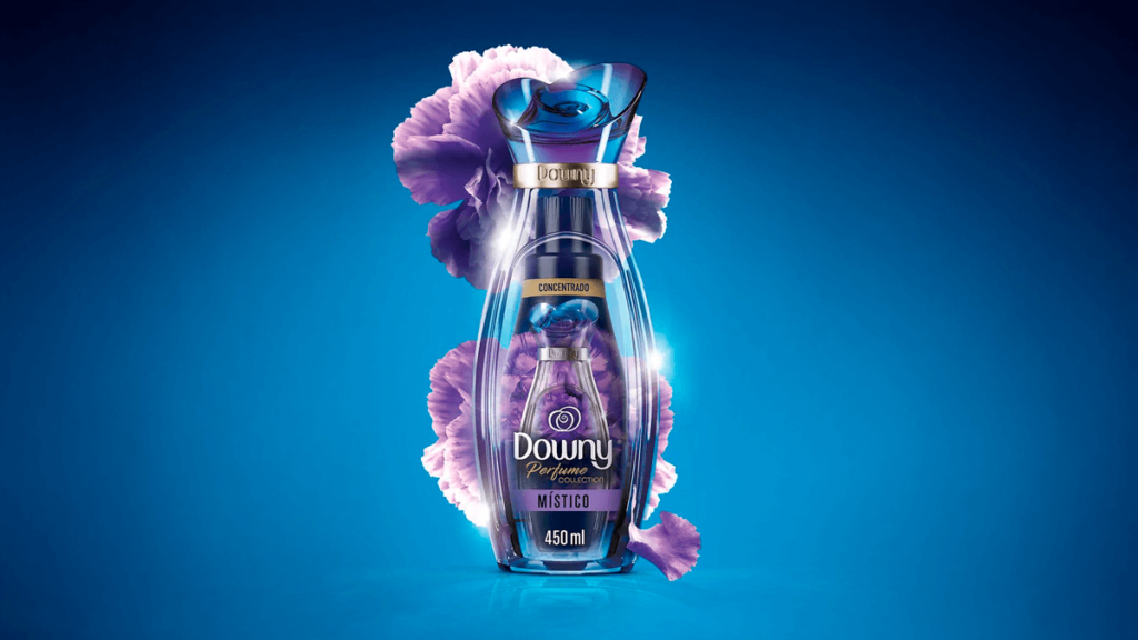 A imagem apresenta o amaciante Downy Perfume Collection Místico, com uma elegante embalagem transparente em tons de roxo, envolta por delicadas flores violetas que simbolizam sua fragrância misteriosa e luxuosa. Com capacidade de 450ml e fórmula concentrada, ele oferece perfume duradouro que transforma as roupas em uma experiência sensorial. Ideal para quem busca o melhor amaciante Downy com uma combinação única de sofisticação e mistério.