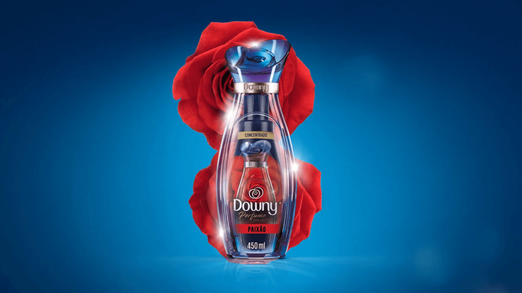 A imagem destaca o amaciante Downy Paixão, em uma elegante embalagem inspirada no luxo e na intensidade, rodeada por uma vibrante rosa vermelha. Com capacidade de 450ml e fórmula concentrada, ele exala notas de frutas vermelhas e flores, proporcionando uma fragrância duradoura e marcante. Ideal para quem deseja o melhor amaciante Downy com um toque de sensualidade, transformando suas roupas em uma experiência olfativa única e irresistível.
