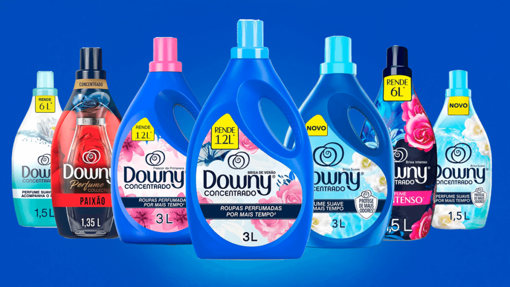 A imagem apresenta a linha completa de amaciantes Downy Concentrado, evidenciando diferentes opções de fragrâncias, como Brisa de Verão, Frescor da Primavera, Paixão e Brisa Intenso. Cada embalagem destaca seu alto rendimento, variando de 6L a 12L, mostrando como o produto é econômico e eficiente. Com a promessa de roupas macias e perfumadas por muito mais tempo, esta linha é ideal para quem procura o melhor amaciante Downy com uma combinação perfeita entre performance e fragrância duradoura.